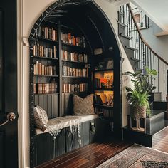 an entry way with bookshelves and stairs leading up to the second floor area