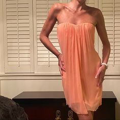 A Gorgeous Pale Coral Strapless Dress. It Has A Sweetheart Bust Line With A Center Draped Pleating That Creates A Flowing Line Down The Middle. Has Boning With An Elastic Bra-Like Closure In The Back With An Exposed Zipper Under The Open Back. Has A More Satiny Lining And It Is Brand New With Tags. Flirty Strapless Sheer Dress, Peach Strapless Summer Dress, Peach Strapless Dress For Summer, Summer Peach Strapless Dress, Flowy Strapless Mini Dress, Strapless Peach Dress For Spring, Peach Strapless Dress For Spring, Strapless Sheer Mini Dress For Cocktail, Elegant Pink Strapless Dress For Beach