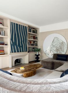 a living room filled with furniture and a large round mirror on the wall above it