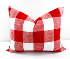 a red and white checkered pillow sitting on top of a table