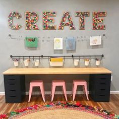 a desk with three stools in front of it and the word create on the wall