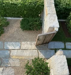 an aerial view of a garden with stone walls and steps leading up to the door