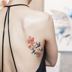 the back of a woman's shoulder with flowers on it