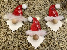 three red and white santa hats with pom poms on top of each other