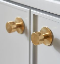 two white cabinets with gold handles and knobs