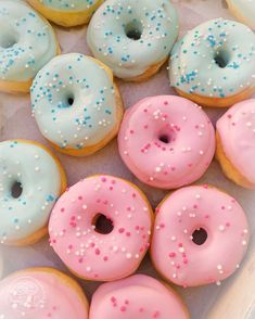 there are many donuts with pink, blue and white frosting on the top