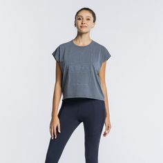 a woman in grey shirt and black leggings