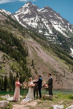 the bride and groom are getting married by the mountain