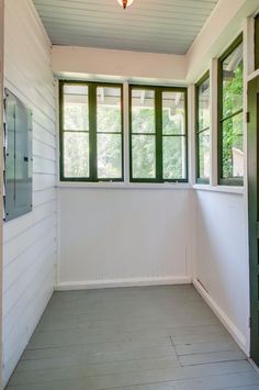 an empty room with three windows and white walls