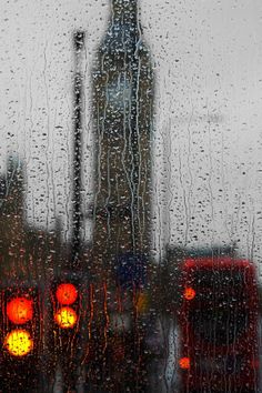 traffic lights are seen through the rain covered window