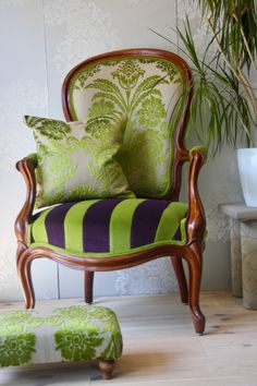 a green and purple chair sitting next to a potted plant