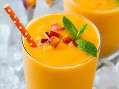 two glasses filled with orange smoothie and garnished with mint