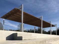 an outdoor covered area with concrete steps and benches