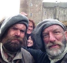 two men with beards are standing in front of other people wearing hoodies and hats