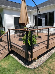 a deck with an umbrella and chairs on it