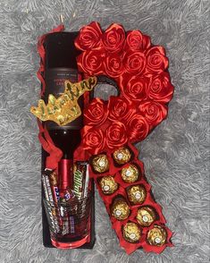 a bottle of wine and some chocolates in a gift box on a gray carpet