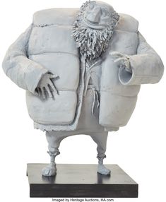 a statue of a man in a jacket and hat with his hands out to the side