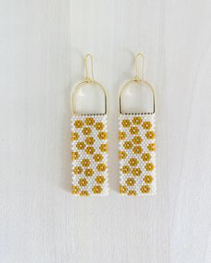 Ochre, white and gold accent glass bead statement earrings inspired by a field of daisies. Each bead is hand sown row after row. Glass beads reveal a beautiful shine as they catch the light. Could be worn daily or on a special occasion. Lightweight design! Make a statement with these handmade bead earrings with a modern and bold design.  Minimalist with a pop of color to brighten up any outfit or occasion. 14K plated gold earring components. Field Of Daisies, Daisy Garden, Daisy Field, Design Minimalist, Gold Earring, Gold Accent, Bold Design, Handmade Beads, Loom Beading