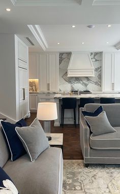 a living room filled with furniture next to a kitchen