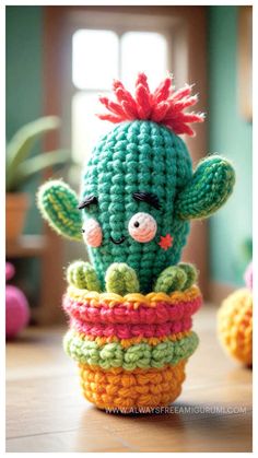 a crocheted cactus sitting on top of a wooden table