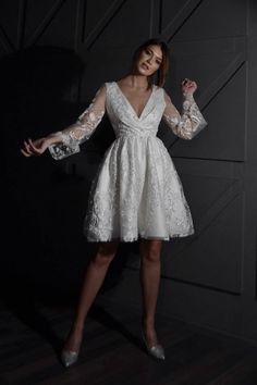 a woman posing in a white dress with her arms spread out and hands extended up