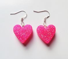 Cute small bright pink glitter heart earrings. Pink glitter sparkle hearts on silver fishook earrings posts. Pink Heart Cut Earrings For Party, Pink Glitter Heart Earrings For Party, Cute Pink Earrings With Heart Print, Pink Double Heart Earrings For Party, Pink Glitter Earrings For Valentine's Day, Cute Pink Double Heart Earrings, Cute Pink Glitter Earrings, Cute Pink Heart Print Earrings, Pink Glitter Jewelry For Gift