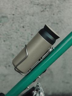 a close up of a bike handlebar with a cup on the top tube and bottom tube