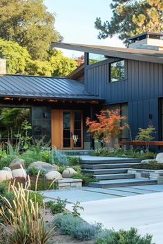 a modern house with stone steps leading up to the front door and landscaping area on both sides