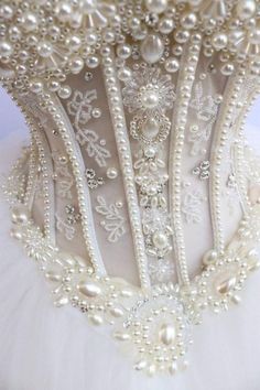 the back of a wedding dress with pearls on it