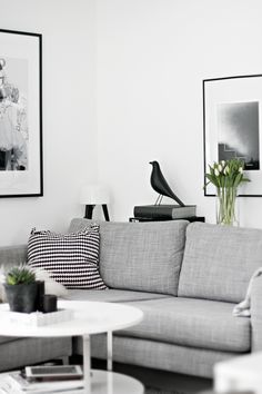 a living room filled with lots of furniture and pictures on the wall above it's coffee table