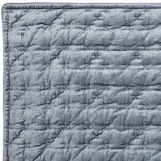 a blue quilted blanket on a white background