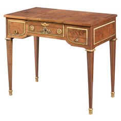 an antique desk with two drawers on one side and gold trimmings on the other