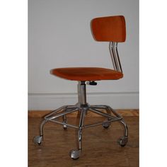 an orange office chair sitting on top of a hard wood floor