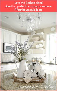 the kitchen island is decorated with white dishes and vases on it's tray