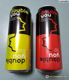 two cans of energy drink sitting next to each other on top of a white table