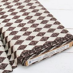 a brown and white checkered cloth on top of a wooden floor