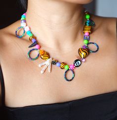 a woman wearing a colorful necklace with scissors and beads