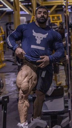 a man is running in the gym with his muscles ripped off and wearing a blue shirt