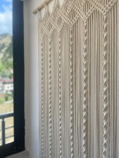 the curtain is made from yarn and has fringes on it, along with a window sill