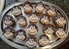 twelve cupcakes with chocolate frosting and monkey faces on them sitting in a pan