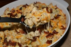 a spoonful of macaroni and cheese is being lifted from the casserole dish