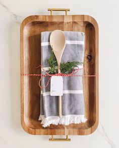 a wooden spoon sitting on top of a cutting board next to a white and gray towel