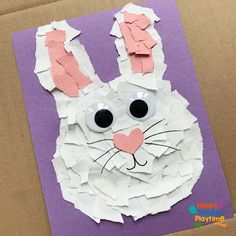 an easter bunny made out of paper on top of a purple sheet of paper with googly eyes