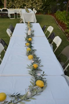 a long table with lemons and greenery on it