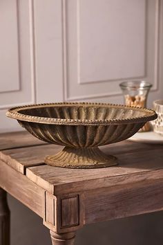 a large metal bowl sitting on top of a wooden table