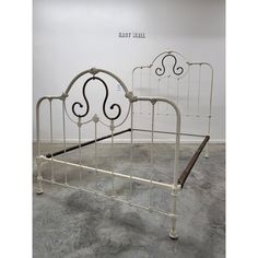 a white metal bed frame with scroll designs