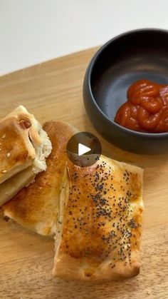 some food is sitting on a wooden table next to a bowl with sauce in it