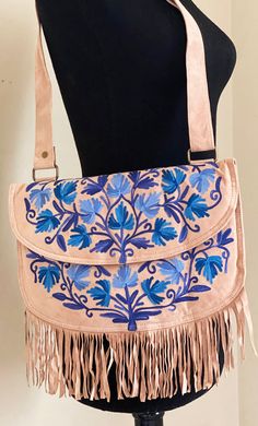 Kashmiri chain stitch floral embroidery on the front, The bag comes with a main compartment, a small zipper coin pocket inside and a zipper pocket when the embroidered flap is lifted, the flap also has a metal stud to keep it close.  The top of the bag has a wide, adjustable shoulder strap to convert from a cross body to hand bag.  The suede bag is lined and lightly padded. Each bag has unique beautiful floral embroidery on the front in vibrant colors, designed by artisans from Kashmiri, India. This bag is perfect as a crossbody or shoulder bag the options are endless. A bag to keep travel  Essential while traveling.  A gift for anyone that loves unique handmade keepsakes. Please select gifting options. Features: * Flap Cover * small zippered pocket under the flap * Inner zipper pocket * A Floral Embroidered Shoulder Bag For Travel, Floral Embroidered Satchel Shoulder Bag For Travel, Floral Embroidered Pouch Shoulder Bag For Travel, Floral Embroidered Crossbody Travel Bag, Bohemian Pouch Shoulder Bag With Floral Embroidery, Bohemian Embroidered Pouch Shoulder Bag, Embroidered Crossbody Shoulder Bag For Travel, Embroidered Shoulder Bag Pouch For Travel, Bohemian Rectangular Shoulder Bag With Floral Embroidery