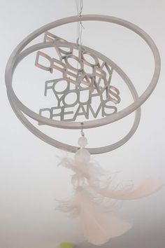 a dream catcher hanging from the ceiling with words above it that read, born to your dreams