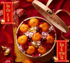 there are many oranges in the bowl on the table with red ribbon around it